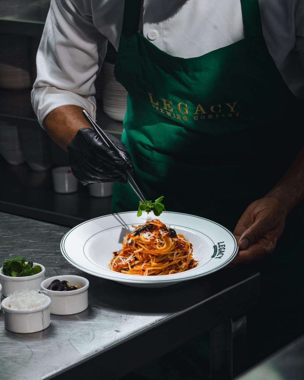 Chef plating pasta in the open kitchen