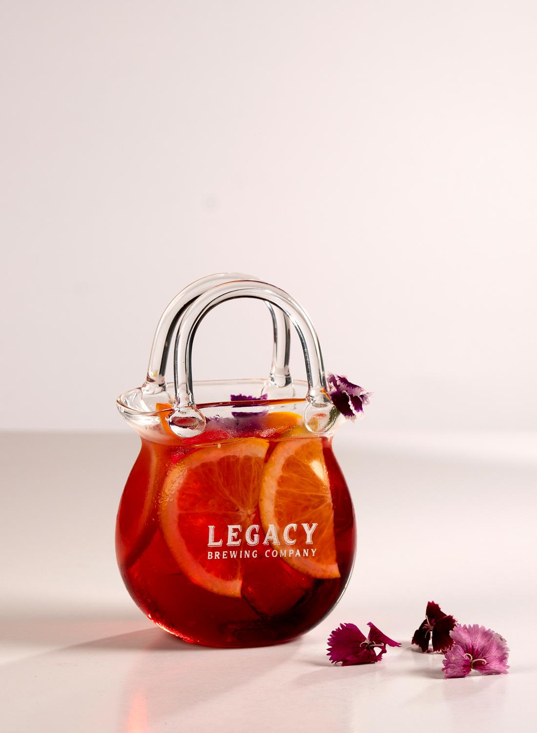 Signature cocktail served in a handbag-shaped glass at Legacy Brewing Company